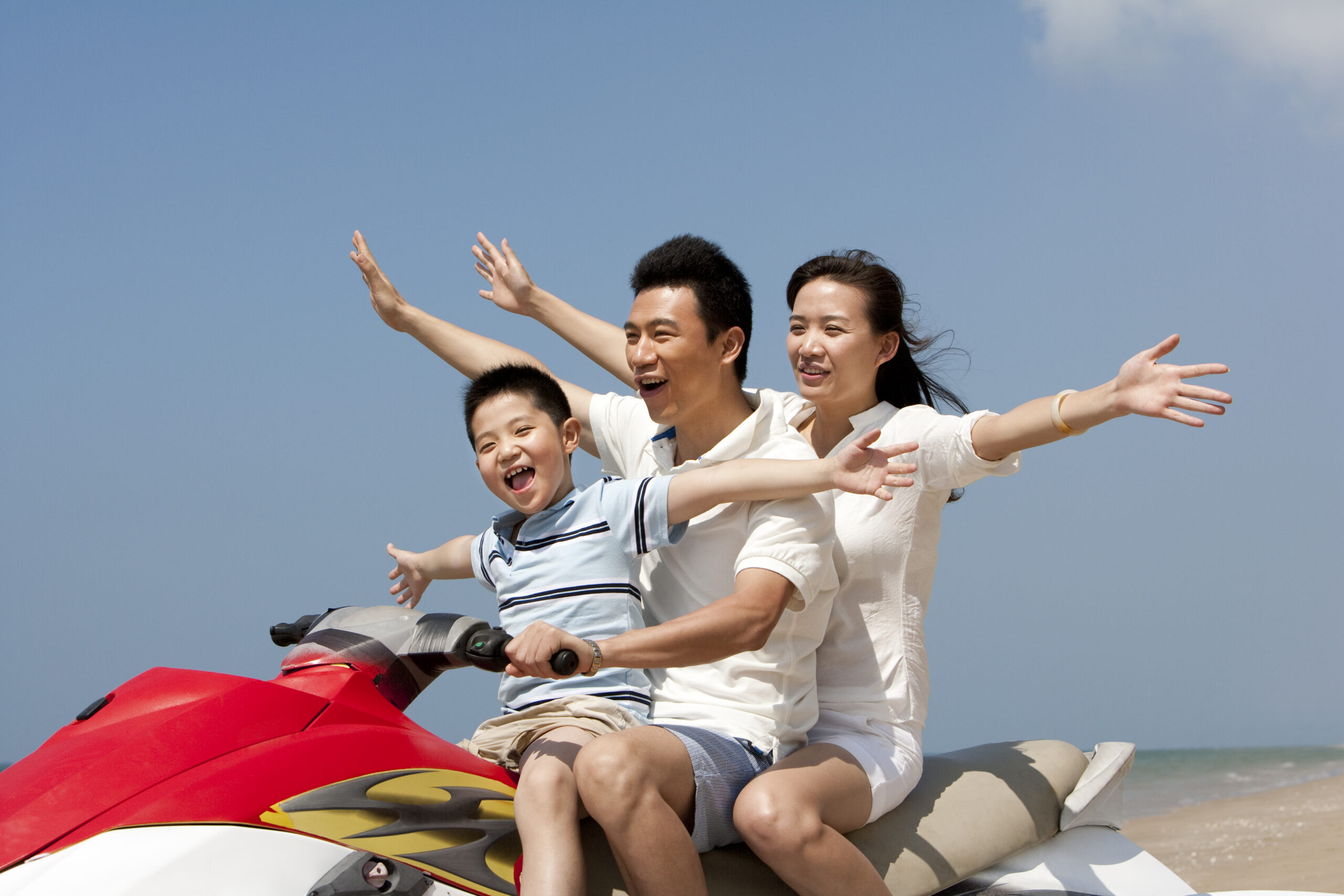Happy Chinese family riding on a jet ski